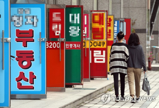 지난 11일 서울 송파구의 공인중개업소들이 밀집한 상가 앞으로 시민들이 걸어가고 있다. 연합뉴스